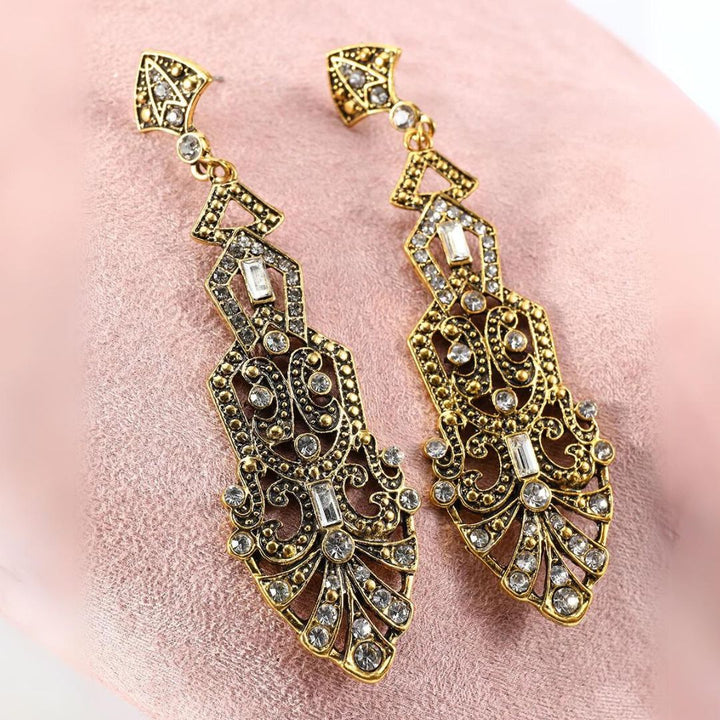 Goldene, verzierte Ohrringe mit Kristallen, Vintage-Stil, Schmuck, luxuriös, elegant.