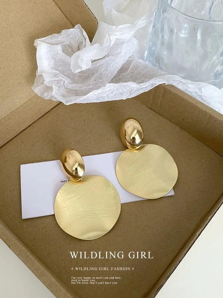 Goldene, runde Ohrringe in Geschenkbox, eleganter Schmuck, modisches Accessoire.