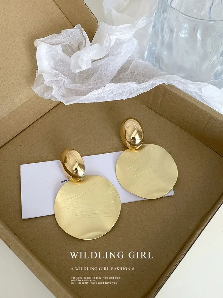 Goldene, runde Ohrringe in Geschenkbox, eleganter Schmuck, modisches Accessoire.
