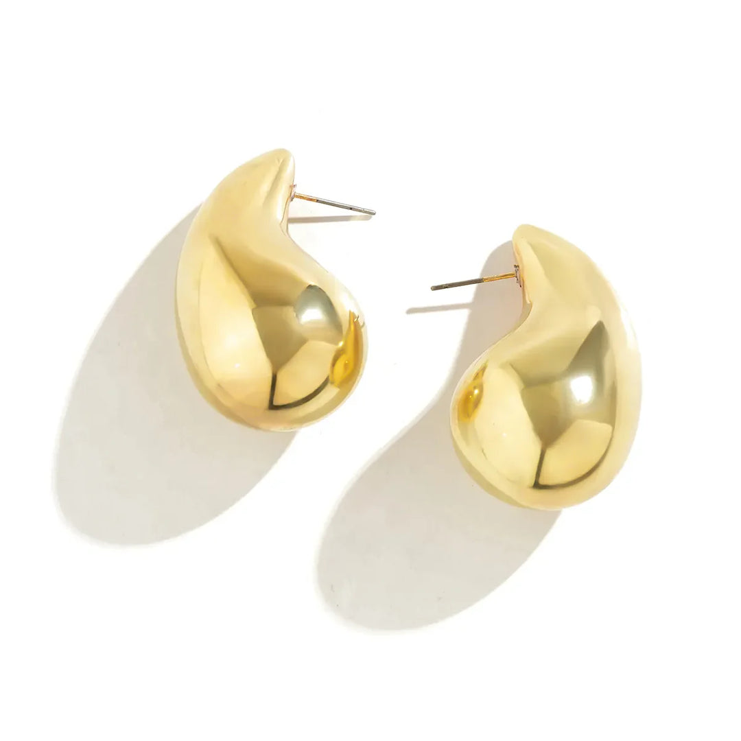 Goldene, organisch geformte Ohrringe, glänzend, modisch, Schmuckaccessoire, Damenmode.