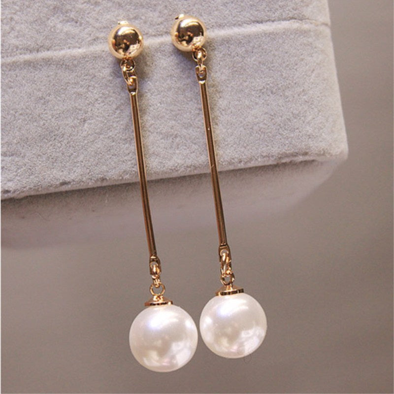 Goldene Ohrringe mit langen Stäben und weißen Perlen, eleganter Schmuck für Damen.