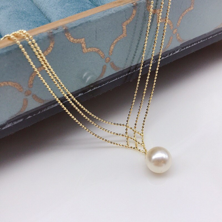 Goldene Halskette mit Perlenanhänger, elegantes Schmuckdesign, luxuriöses Accessoire.