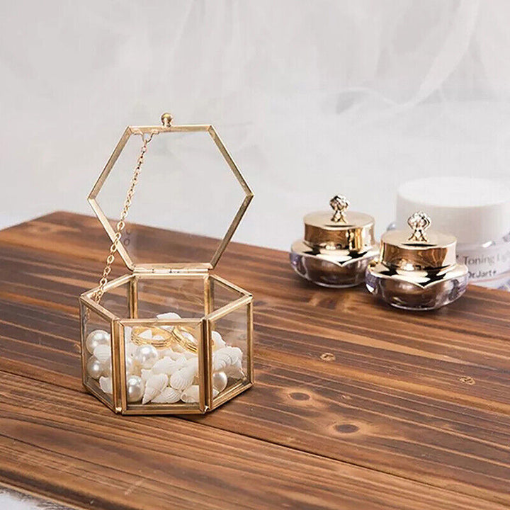 Goldene sechseckige Schmuckbox mit Perlen, Glas, dekorativ, auf Holztisch, luxuriöses Design.
