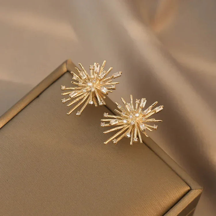 Goldene Ohrringe in Sternform auf beigem Hintergrund, eleganter Schmuck, modisches Accessoire.