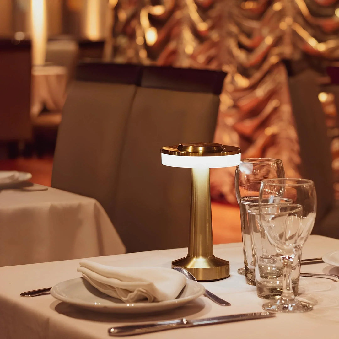 Goldene Tischlampe im Restaurant, modernes Design, elegante Beleuchtung, stilvolle Dekoration.