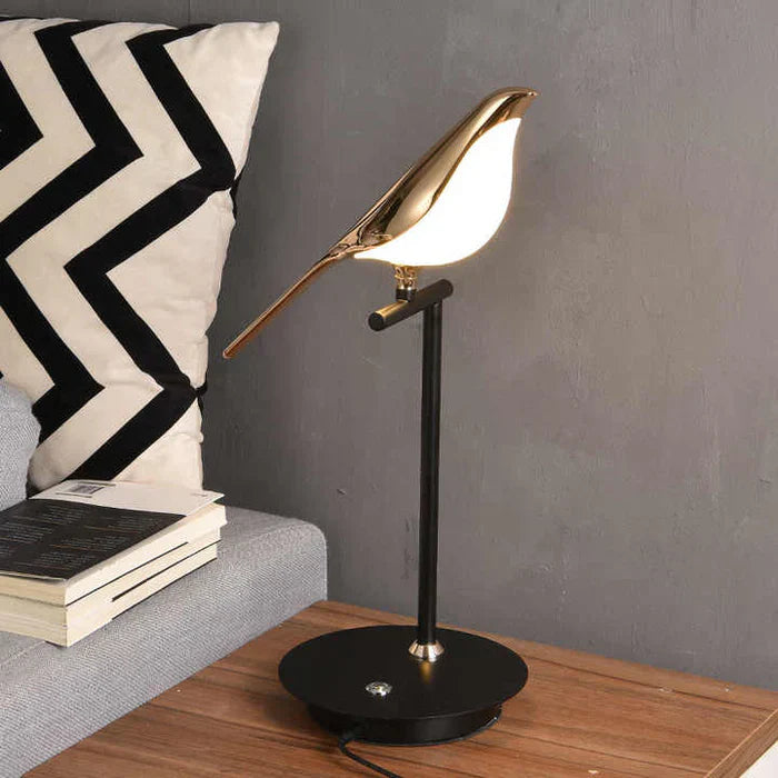 Goldene Vogel-Tischlampe auf Holzoberfläche, modernes Design, LED-Beleuchtung, Wohnzimmer-Dekor.