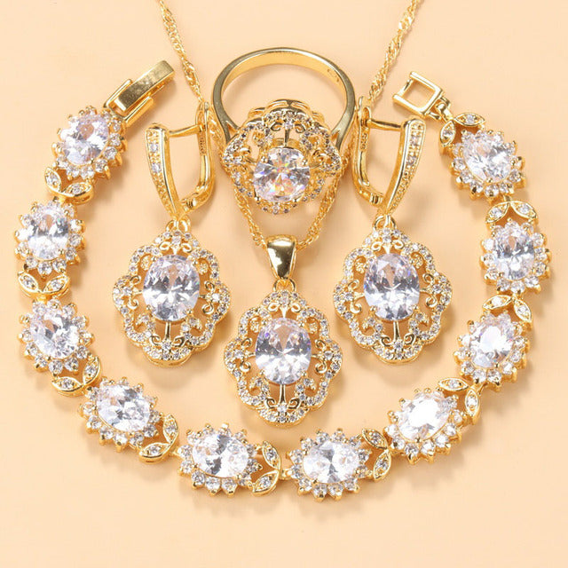 Goldene Schmuckset mit Zirkonia, bestehend aus Armband, Ring, Ohrringen und Halskette.