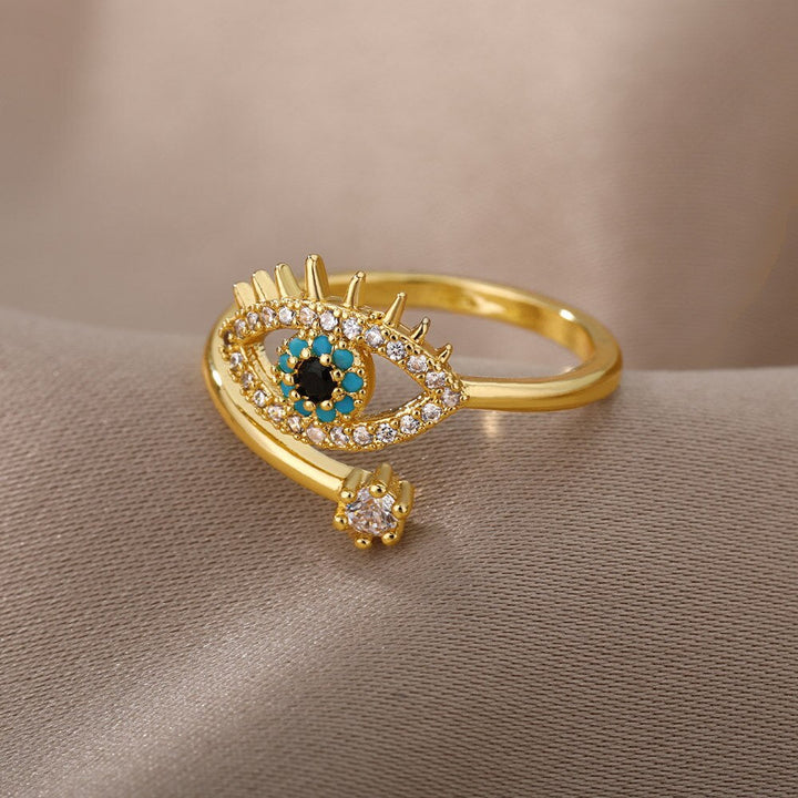Goldener Ring mit Auge-Design, Zirkonia-Steinen, türkisfarbenen Akzenten, modischer Schmuck.