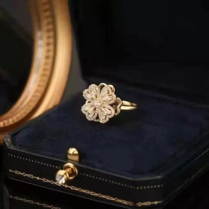 Goldener Blumenring auf schwarzem Samtkissen, luxuriöses Schmuckdesign, elegantes Accessoire.