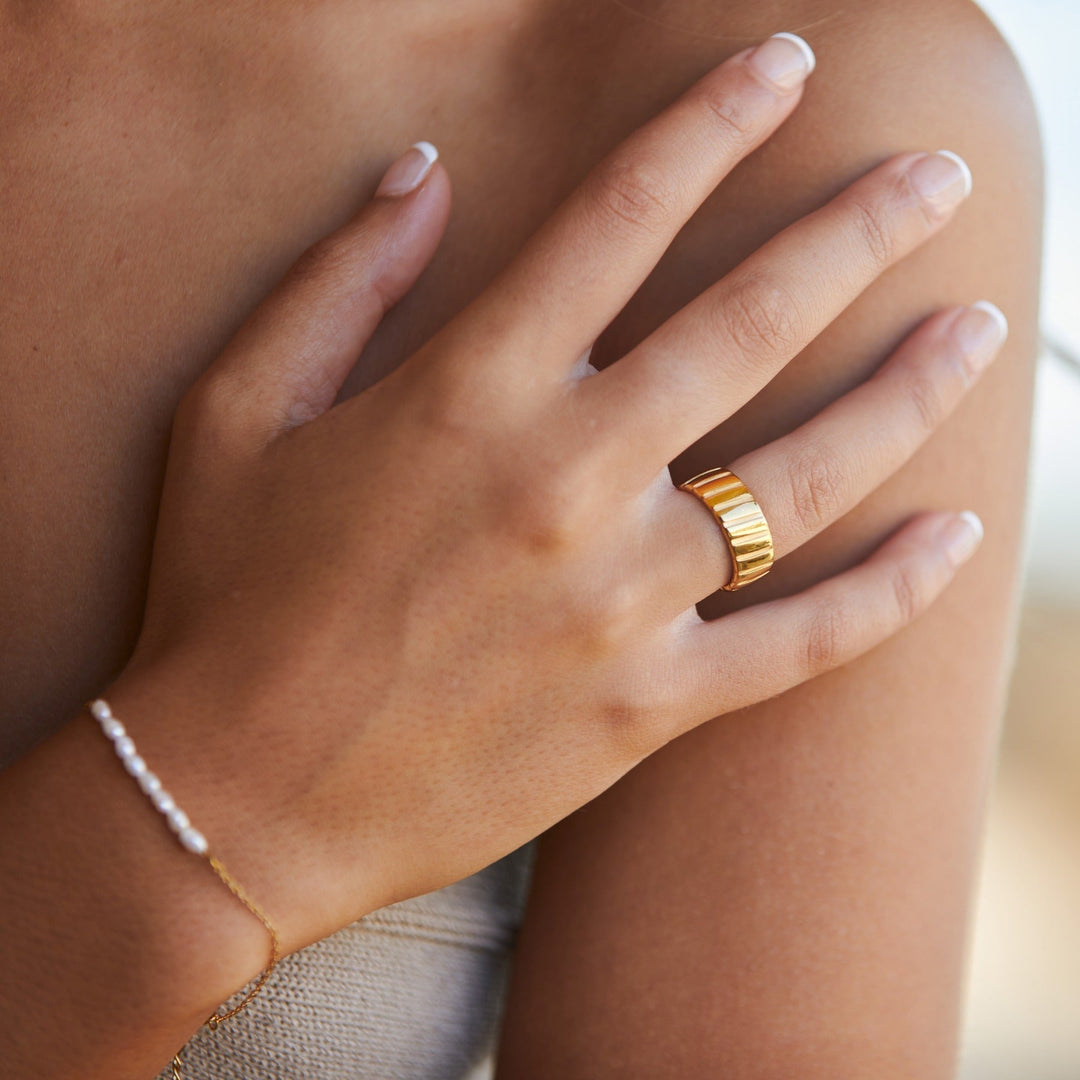 Goldener Statement-Ring an Hand, modernes Design, Schmuck, Damenmode, Accessoire, elegant.