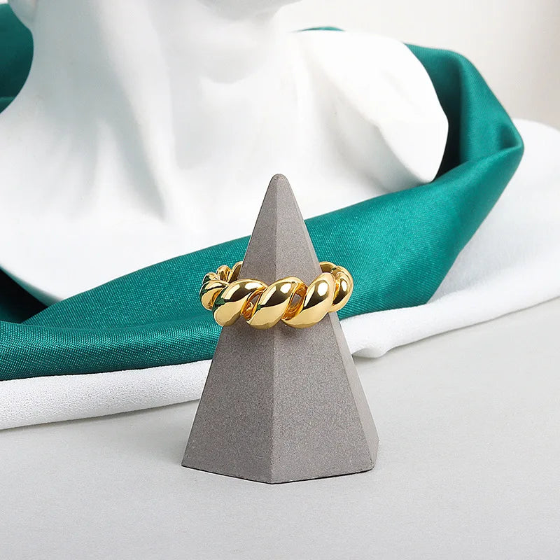 Goldener Ring auf grauem Kegel, Schmuck, glänzend, modisch, Accessoire, Dekoration, Display.