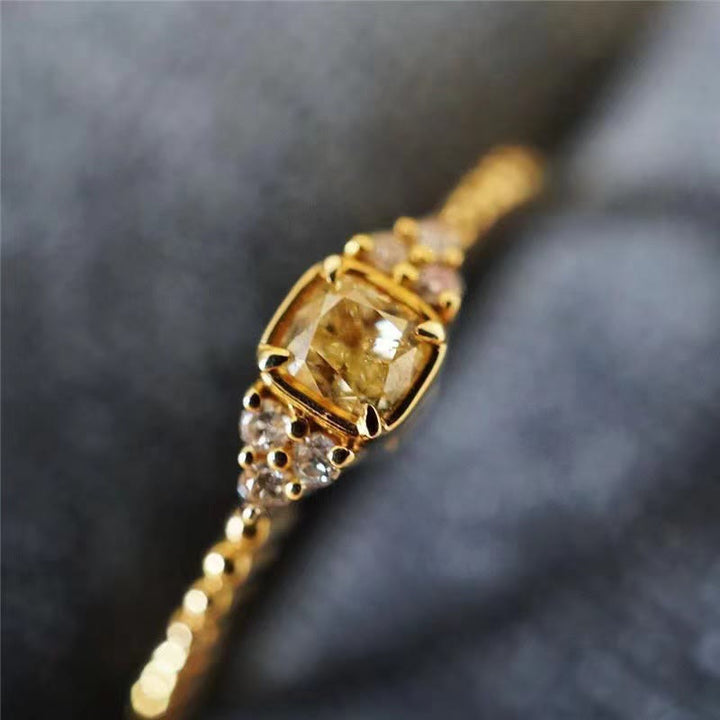 Goldener Diamantring mit gelbem Diamant, filigranes Design, luxuriöser Schmuck, Nahaufnahme.