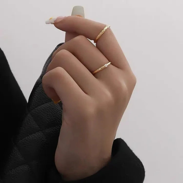 Goldener Doppelring an Hand, minimalistisch, elegant, Schmuck, Damenmode, Accessoire, stilvoll.