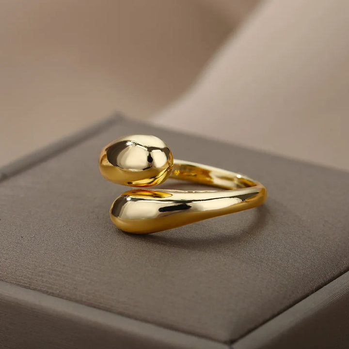 Goldener, minimalistischer Ring auf grauem Hintergrund, elegantes Schmuckdesign, glänzend.