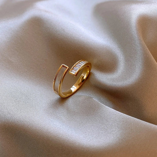Goldener offener Ring auf beigem Satin, minimalistisches Design, eleganter Schmuck.
