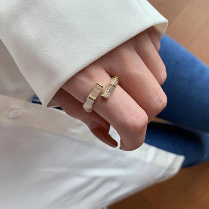 Goldener, verstellbarer Ring mit Zirkonia-Steinen auf Hand, elegantes Schmuckdesign.