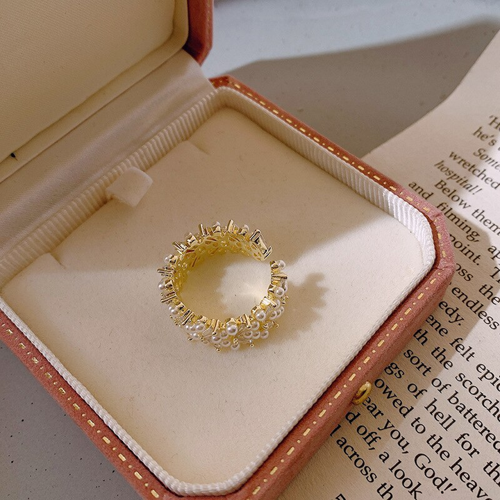 Goldener Ring mit Perlen und Kristallen in Schmuckschatulle, elegantes Design, luxuriöses Accessoire.