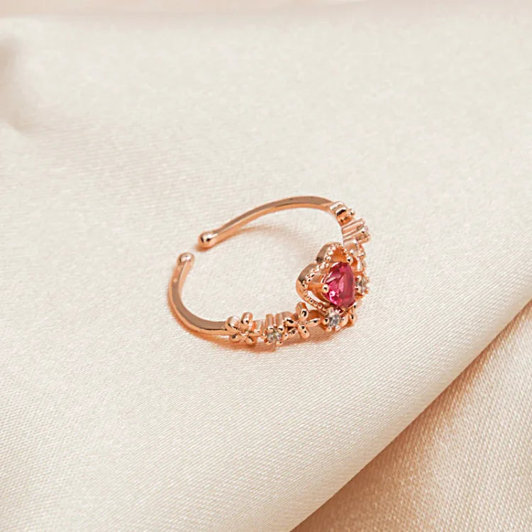 Goldener Ring mit rotem Herzstein, Blumenmuster, Damenmode, Schmuck, elegantes Design.