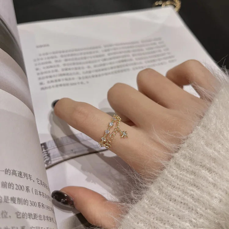 Goldener Damenring mit Kristallen, filigranes Design, auf Hand getragen, eleganter Schmuck.