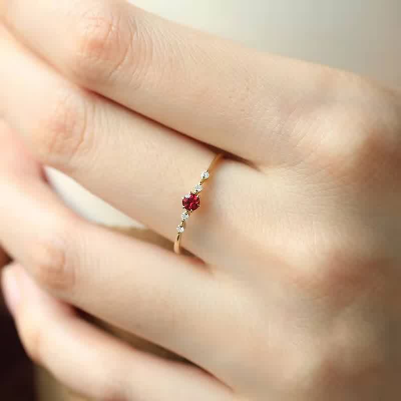 Dünner Goldring mit rotem Edelstein und kleinen Diamanten, eleganter Schmuck für Damen.