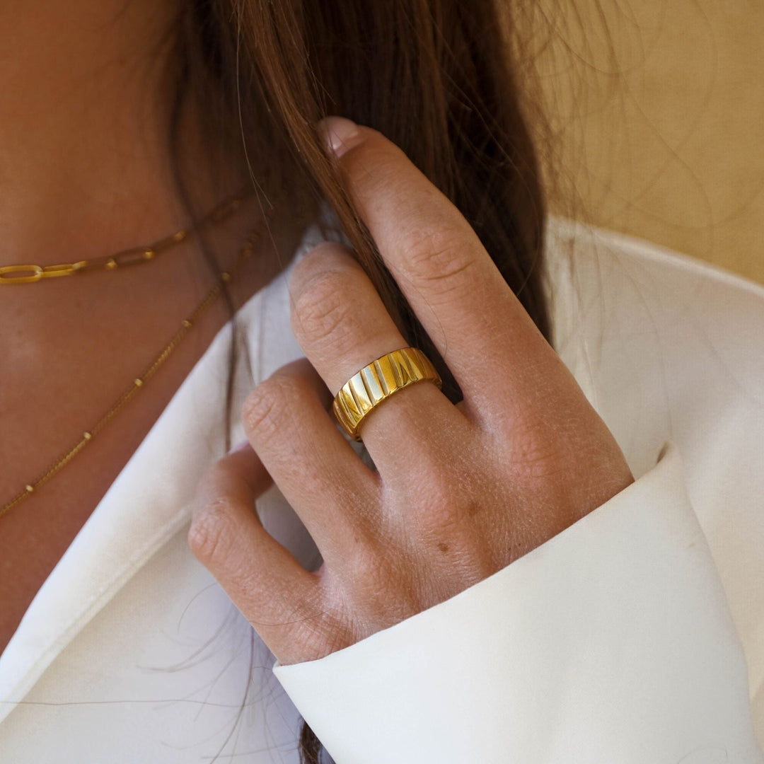Goldener Ring an Frauenhand, Schmuck, Modeaccessoire, elegantes Design, glänzend, Damenmode.