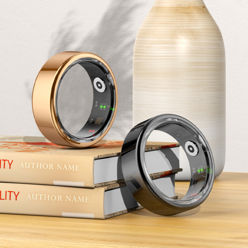 Zwei Smart-Ringe in Gold und Schwarz auf Büchern, moderne Technologie, stilvolles Design.