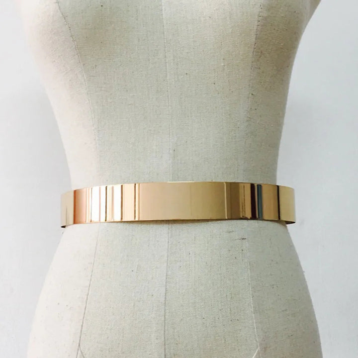 Goldener Metallgürtel auf Schneiderpuppe, modisches Accessoire, glänzend, elegant.