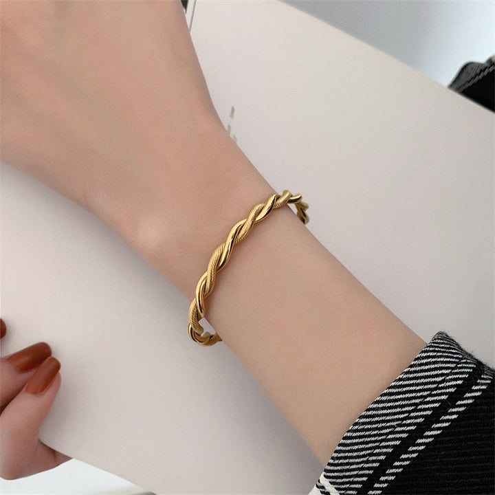 Goldener Twist-Armreif aus Edelstahl, Damen-Schmuck, elegantes Design, modisches Accessoire.