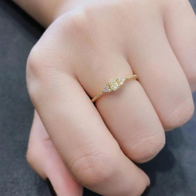 Goldener Verlobungsring mit Diamant auf Hand, elegantes Schmuckdesign, Damenring.