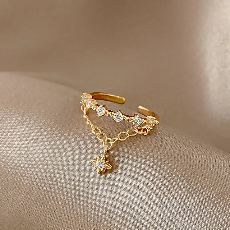 Goldener verstellbarer Ring mit Zirkonia-Steinen und Sternanhänger, eleganter Schmuck.