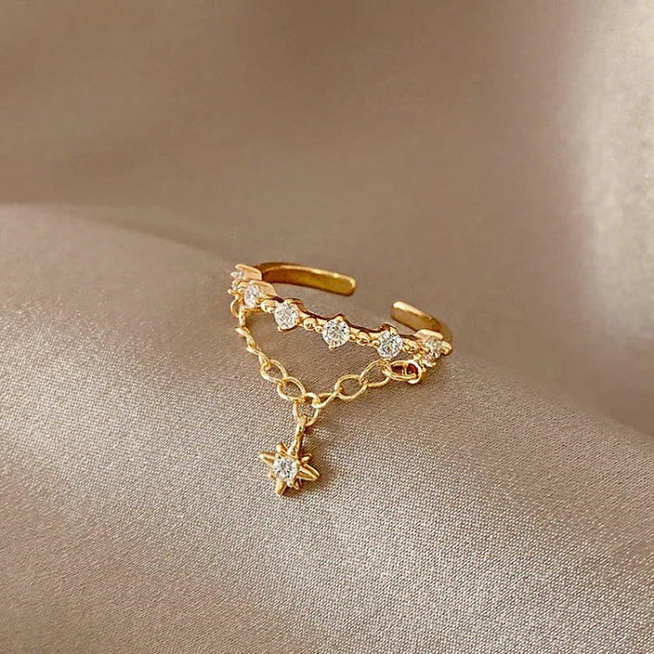 Goldener verstellbarer Ring mit Zirkonia-Steinen und Sternanhänger, eleganter Schmuck.