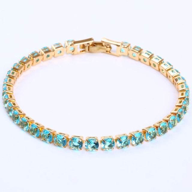 Goldenes Armband mit blauen Edelsteinen, elegantes Schmuckstück, luxuriöses Design.