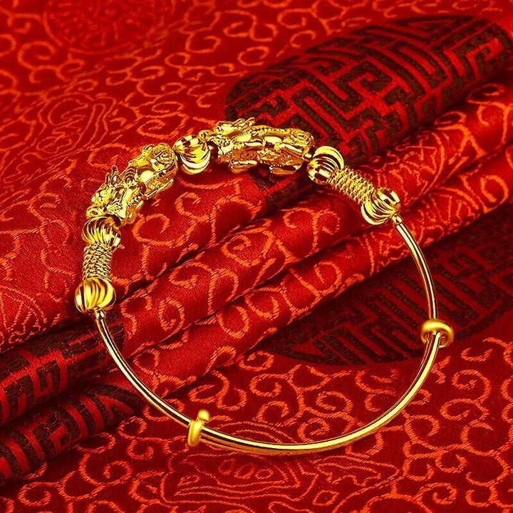 Goldenes Armband mit Drachenmotiv auf rotem Seidenstoff, traditionelles chinesisches Design.