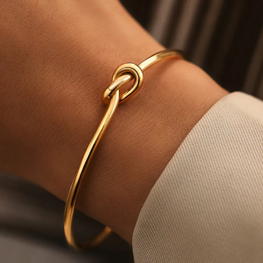 Goldenes Armreif mit Knoten-Design, eleganter Schmuck, modisches Accessoire für Damen.