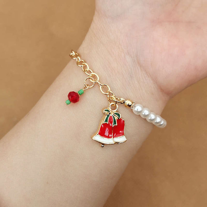 Goldenes Armband mit roten Glockenanhängern und Perlen, modisches Schmuckstück für Damen.