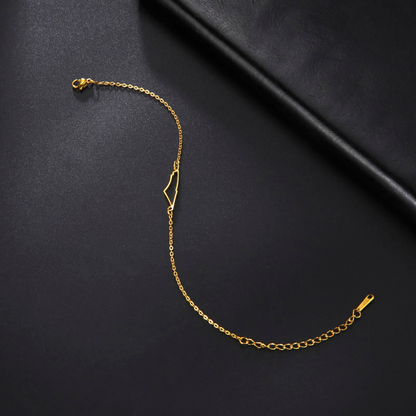 Goldene Armbandkette aus Edelstahl auf schwarzem Hintergrund, minimalistisches Design.