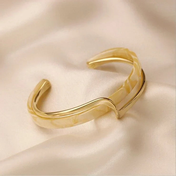 Goldener Armreif auf Seide, elegantes Schmuckdesign, modischer Accessoire-Trend.
