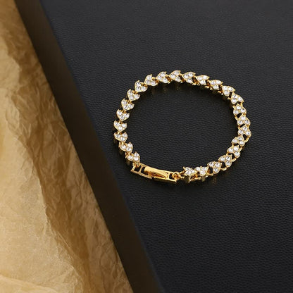 Goldenes Armband mit Zirkonia-Steinen auf schwarzem Hintergrund, eleganter Schmuck für Damen.