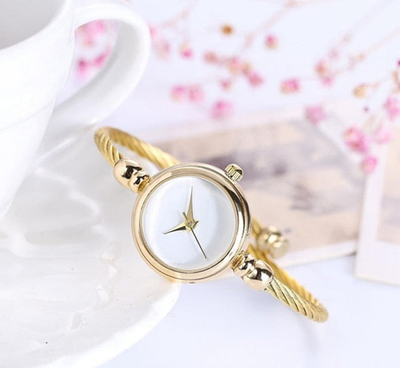 Goldene Damenarmbanduhr mit weißem Zifferblatt, elegantes Design, modisches Accessoire.