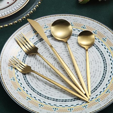 Goldenes Besteckset auf dekorativem Teller, Edelstahl, modern, elegant, Essbesteck, Tischdekoration.