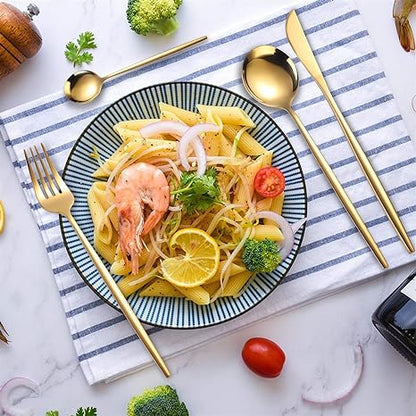 Pasta mit Garnelen, Zitrone, Brokkoli auf gestreiftem Tuch, goldfarbenes Besteck, Tomate.