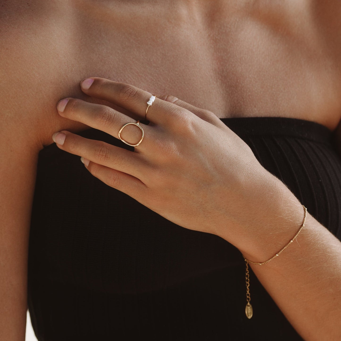 Damenarmband aus Gold mit feinen Perlen, eleganter Schmuck, minimalistisches Design.