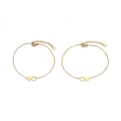 Zwei goldene Armbänder mit Herzanhängern, filigranes Design, Schmuck für Damen.