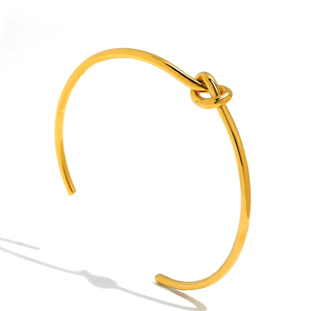 Goldenes Armreif mit Knoten-Design, minimalistischer Schmuck, elegantes Accessoire für Damen.