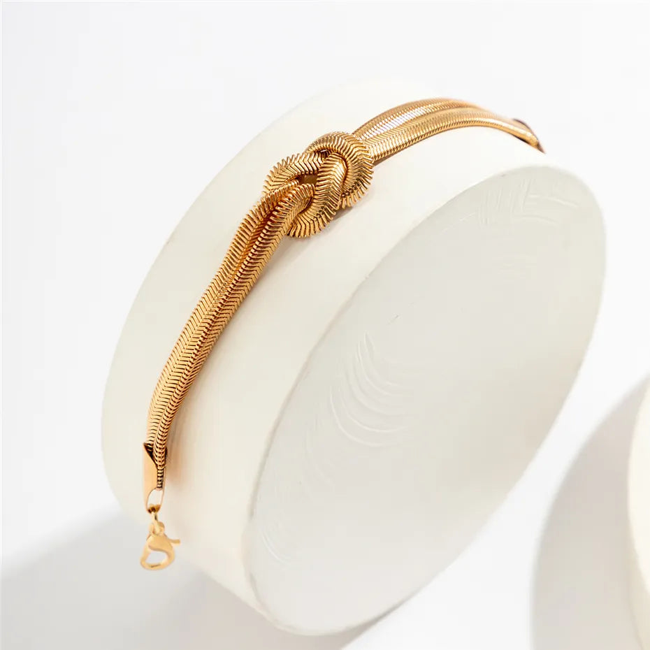 Goldenes Armband mit Knoten-Design, eleganter Schmuck, Damenaccessoire, modisch, Geschenkidee.
