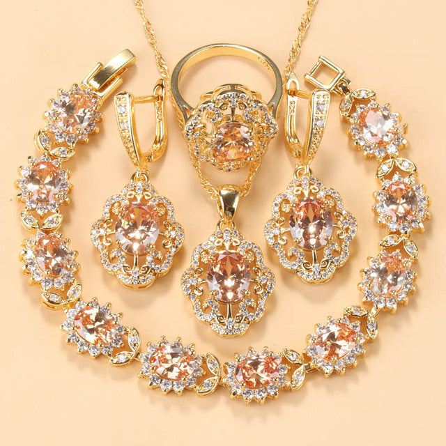 Goldene Schmuckset mit Zirkonia, bestehend aus Armband, Ring und Anhänger, elegant und funkelnd.