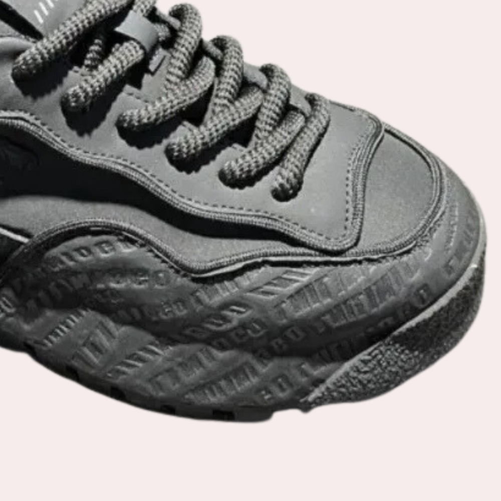 Schwarzer Sneaker mit geprägter Sohle, sportliches Design, Nahaufnahme, modisch, Unisex.