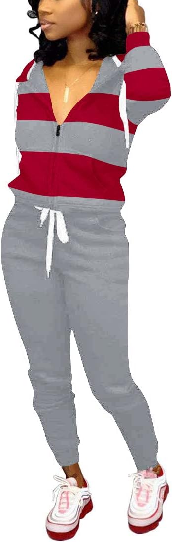 Frau in grauem Jogginganzug mit roten Streifen, Kapuze und weißen Sneakers.