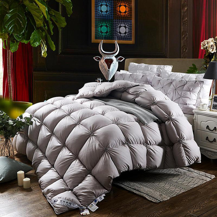 Luxuriöse graue Steppdecke auf Bett, Schlafzimmerdekor, gemütliche Bettwäsche, elegante Einrichtung.