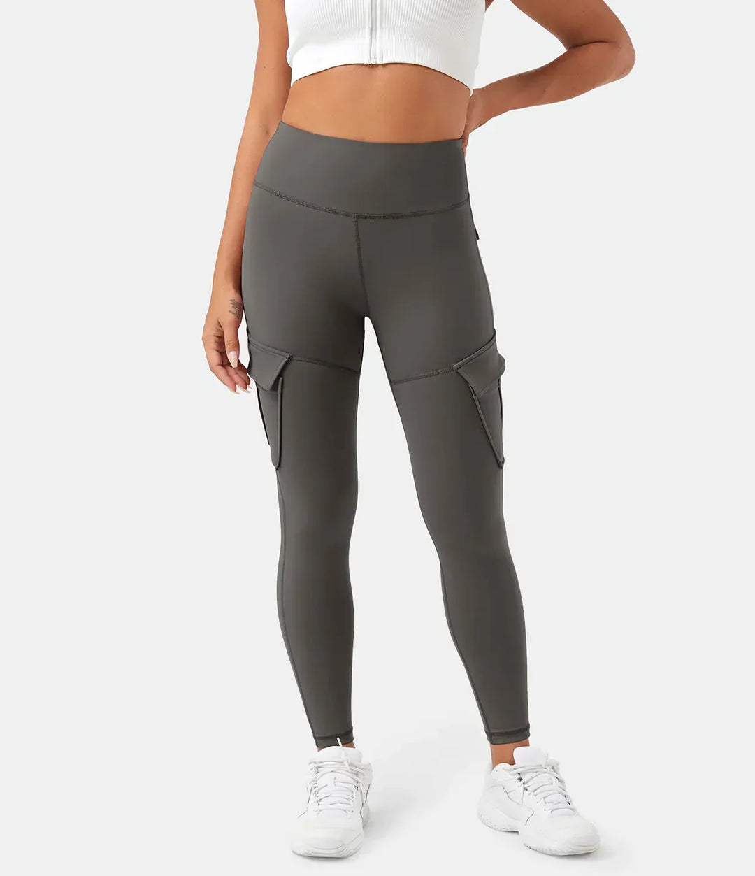 Frau in grauer Cargo-Leggings mit Taschen, sportlich, modisch, bequem, Damenbekleidung.